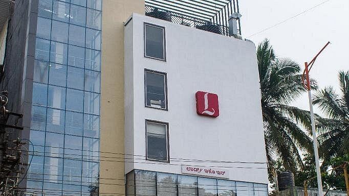Exterior view of our hotel with multiple floors and some greenery in the background - Lords Eco Inn Belagavi