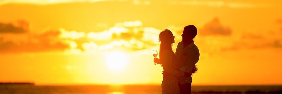 Silhouette of couple holding each other on a beach during sunset
