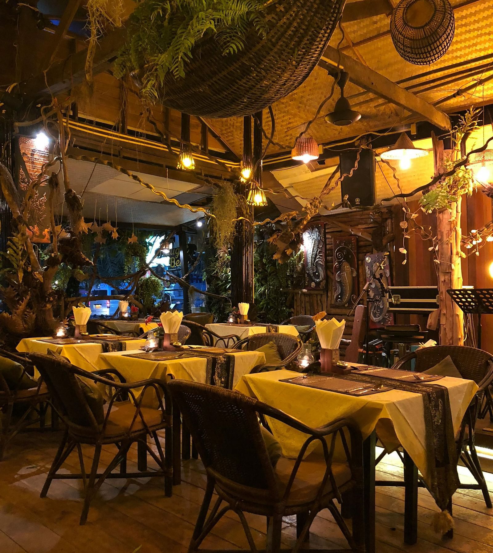 Outdoor dining arrangement at a restaurant with the lights on.
