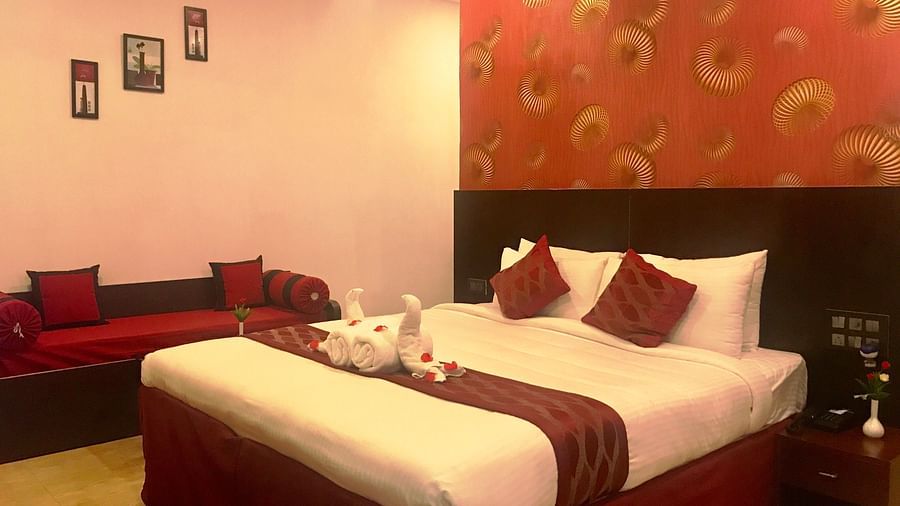 Image of a room with a bed and a table beside it at Parampara Resort & Spa, Kushalnagar.