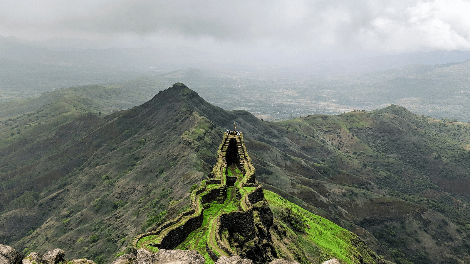 view of the sky and fort above the mountain with dark skies in the background