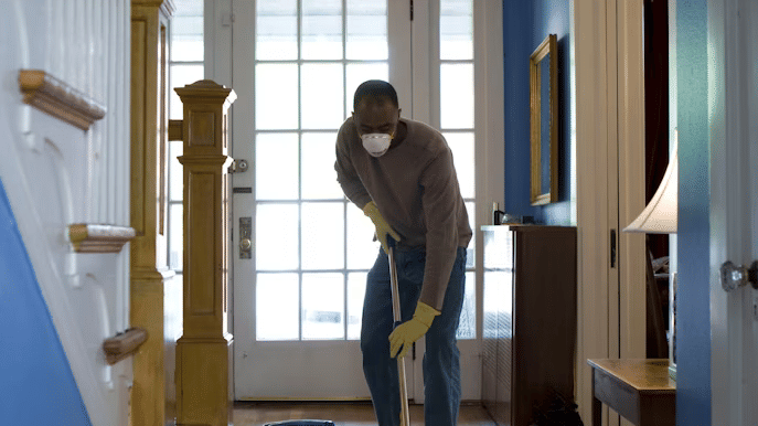 A man cleaning house with a vacuum cleaner