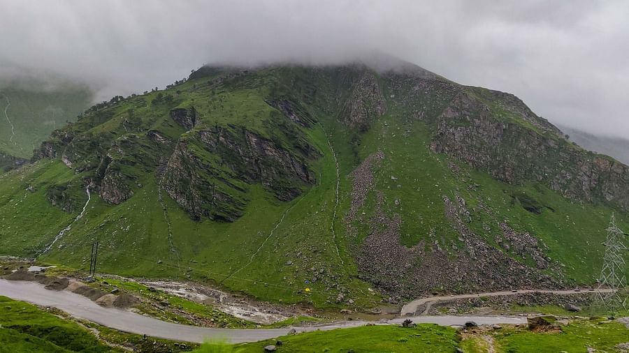 A road surrounded by mountains on a foggy day