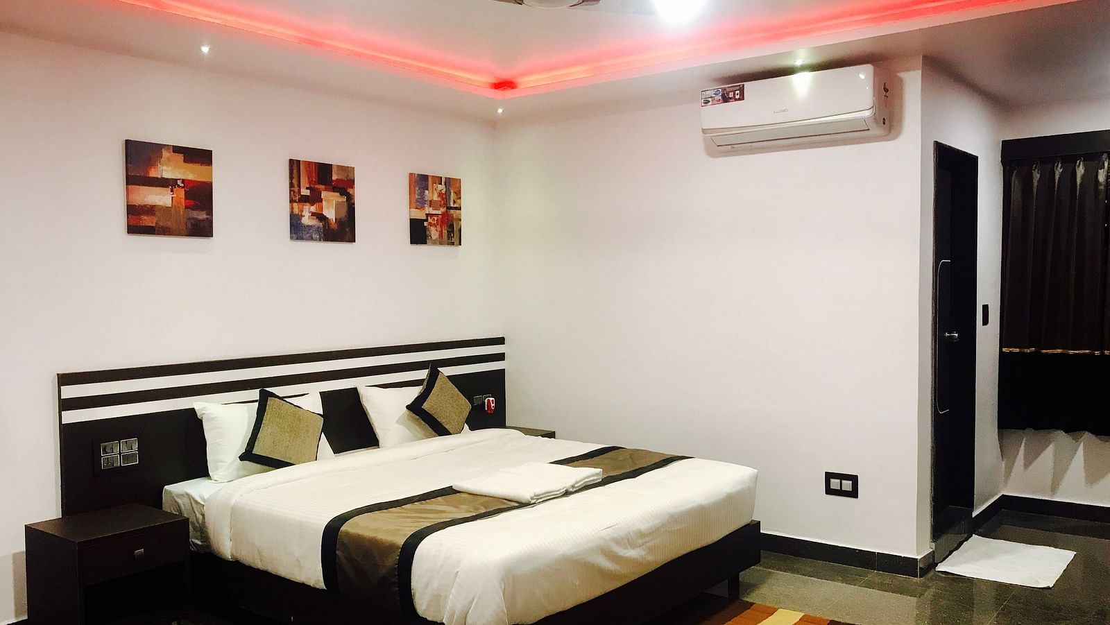 Image of a room with a bed, a ceiling fan, and an air-conditioner at Parampara Residency, Kushalnagar.