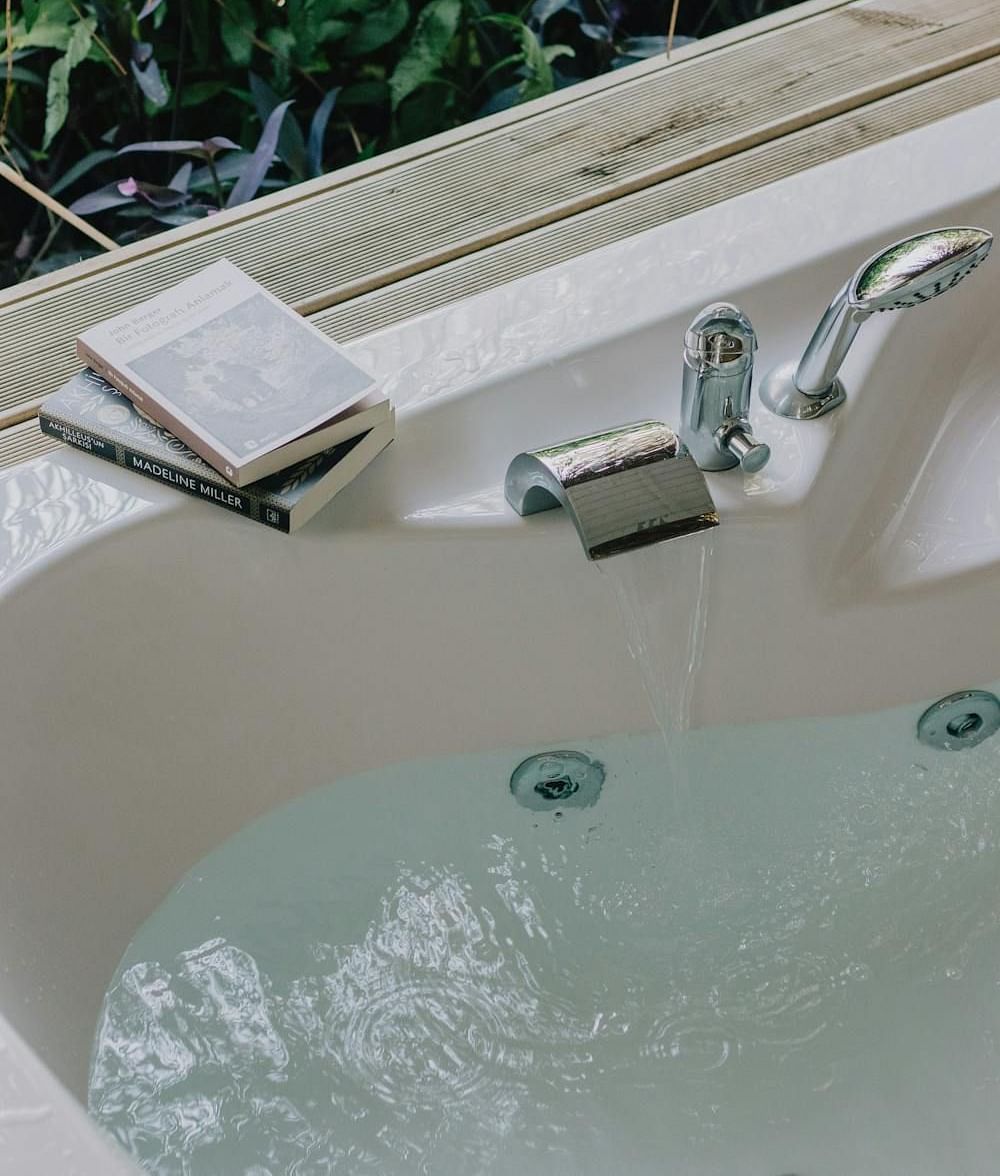 Image of a tub with water and books placed on the edge of it.