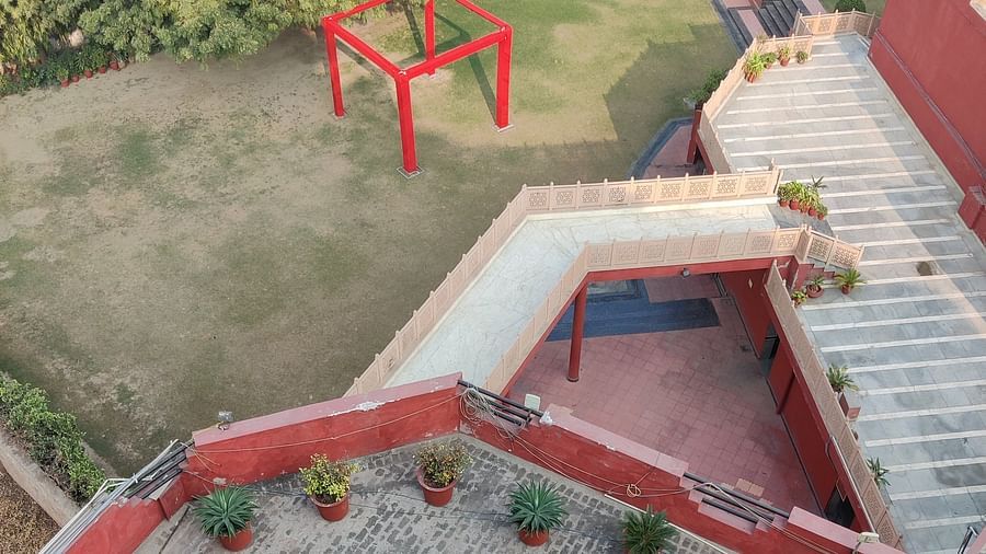 Top angle shot of Hotel Gold, Panipat featuring the lawn area along with a small marble pathway.