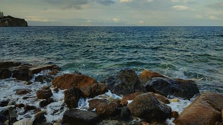 An image of a seaside where shores are hitting the rocks | Ocean Spray