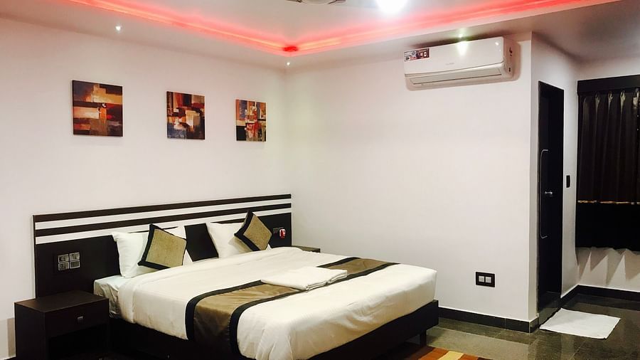 Image of a room with a bed, a ceiling fan, and an air-conditioner at Parampara Residency, Kushalnagar.