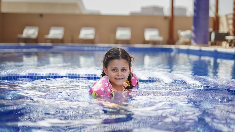 A girl child enjoying swimming inside the Kids Pool - La Maison Hotel, Doha