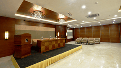 a desk with sofas on the podium inside the Banquet hall - VITS Devbhumi, Dwarka