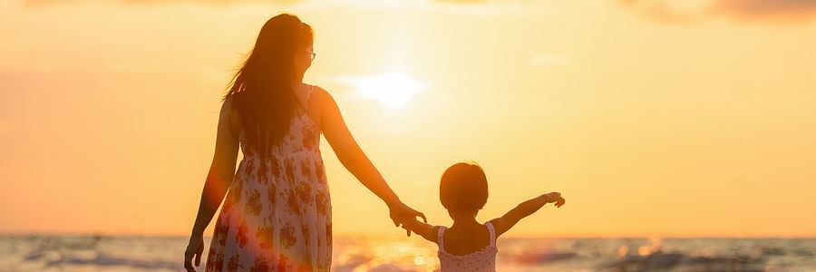 a parent and child admiring a sunset