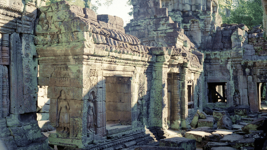 The weathered stone entrance and pillars of an ancient Hindu temple surrounded by trees at Ananta Express, Katra.