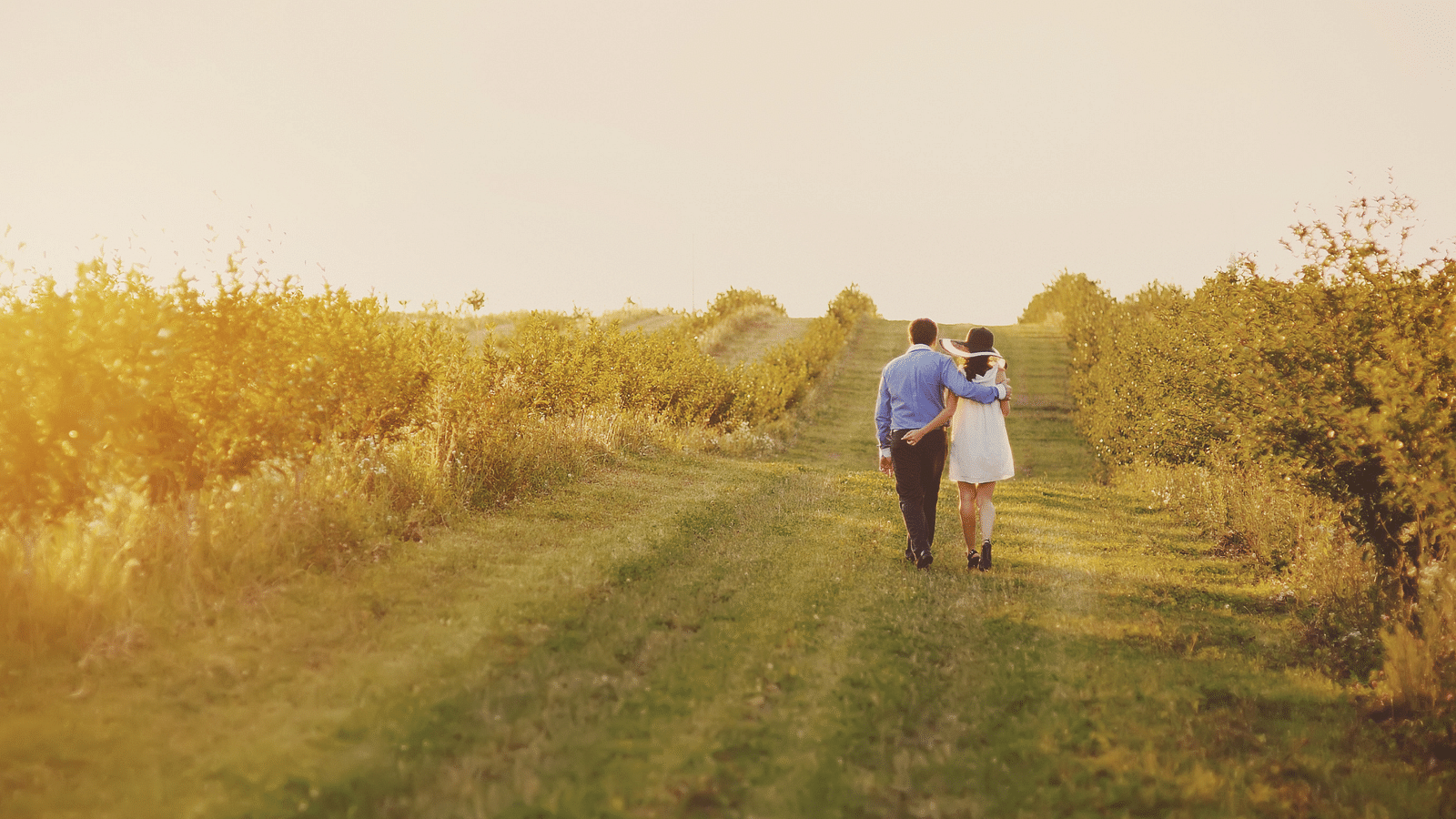 an image of a couple walking on grassy lands - Rhythm Lonavala