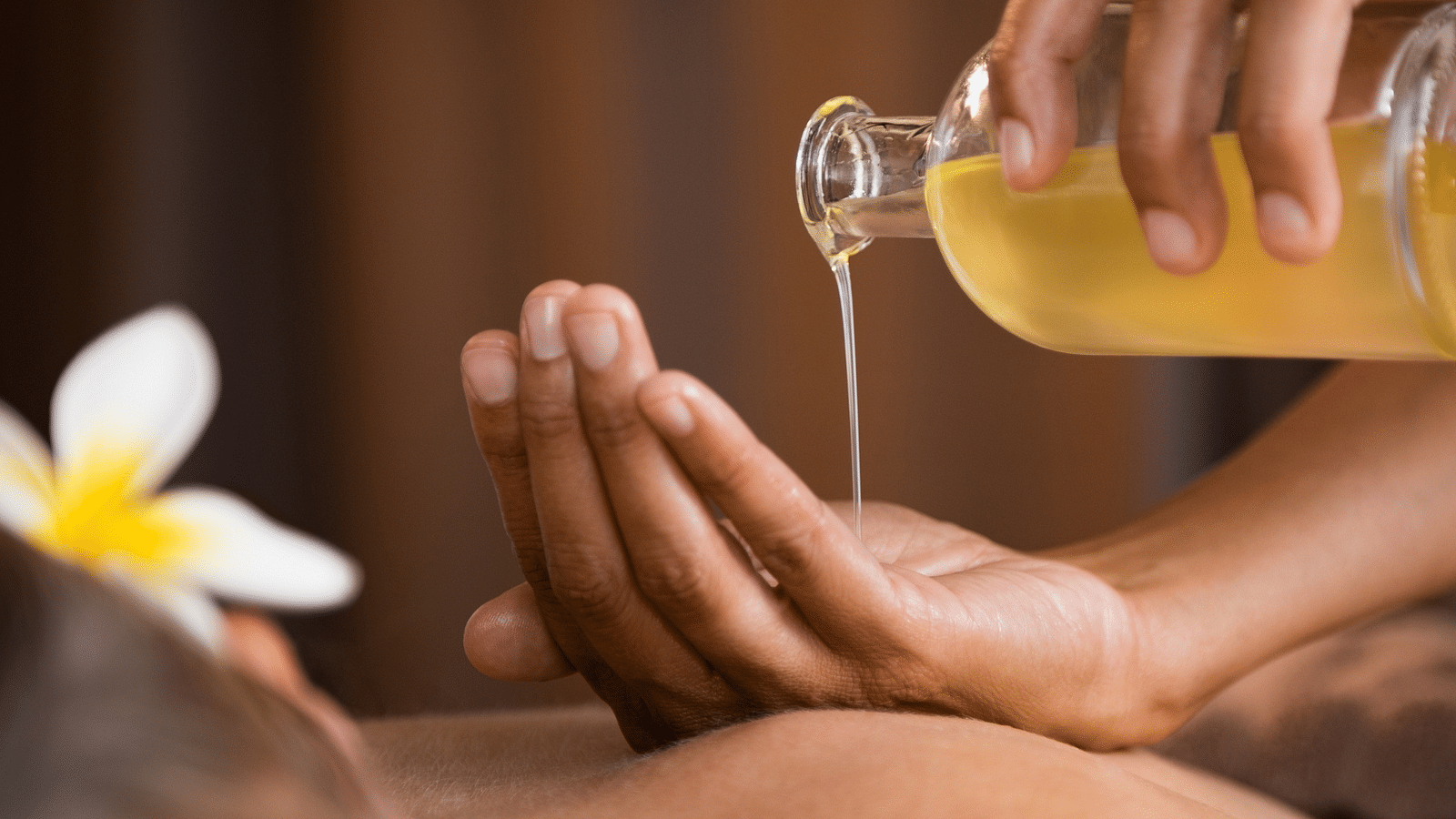 an image of a person pouring oil on their hands to massage their client - Rhythm Lonavala