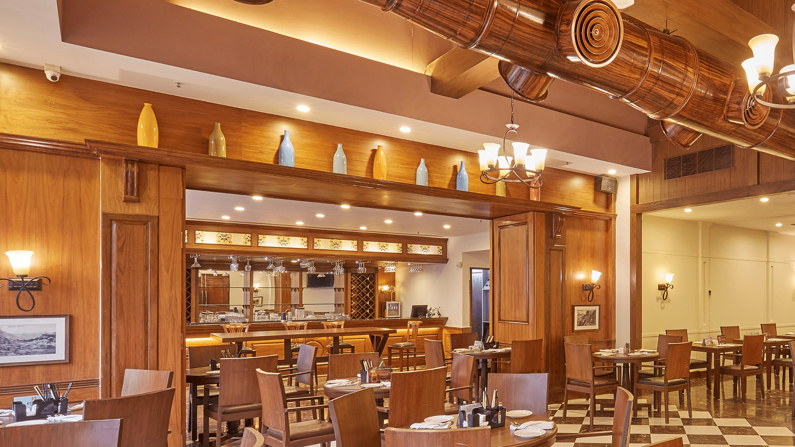 Cedar restaurant features wooden interiors and an elegant dining arrangement - Rhythm Lonavala