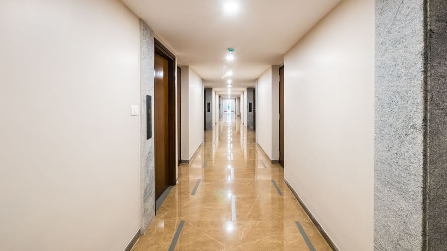 A long well lit corridor with light coloured walls and floors leading to rooms, creating an inviting space at Shilton Dee Cee.