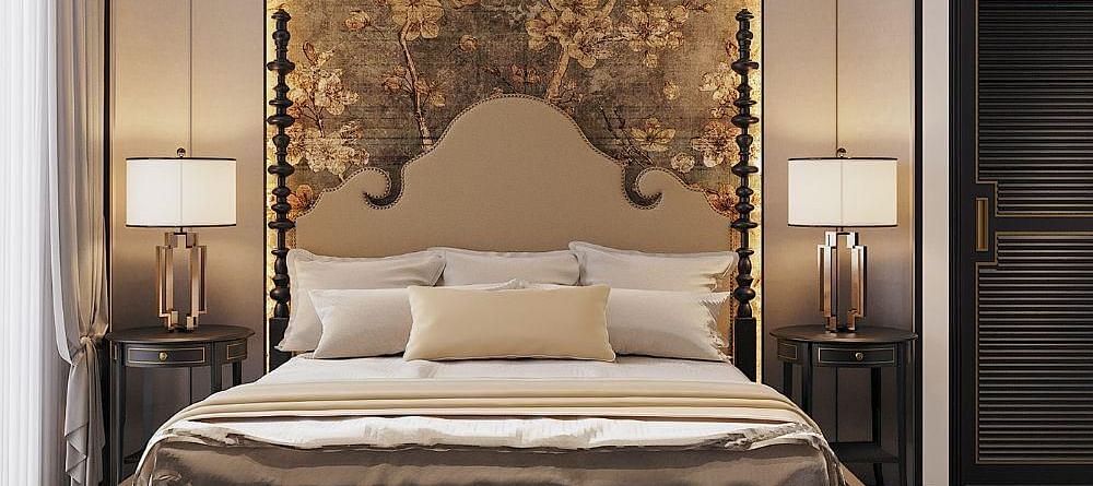 Front view of a well-made bed with cushions, a ceiling fan, and two bedside tables with lamps at The Evren, Vagator.