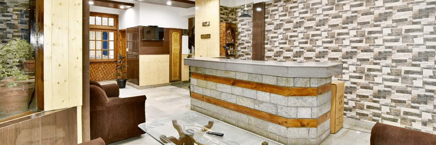 The reception desk in the well-lit lobby area of DLS Hotel Devlok, Manali
