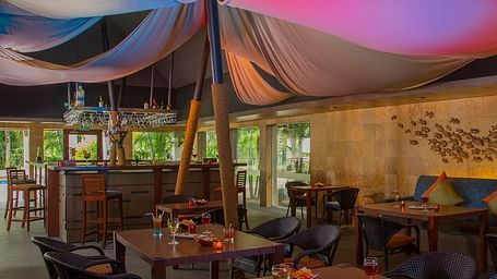 Sindbad Bar-with soft pink lighting, showcasing intimate table settings and an artistic decor.