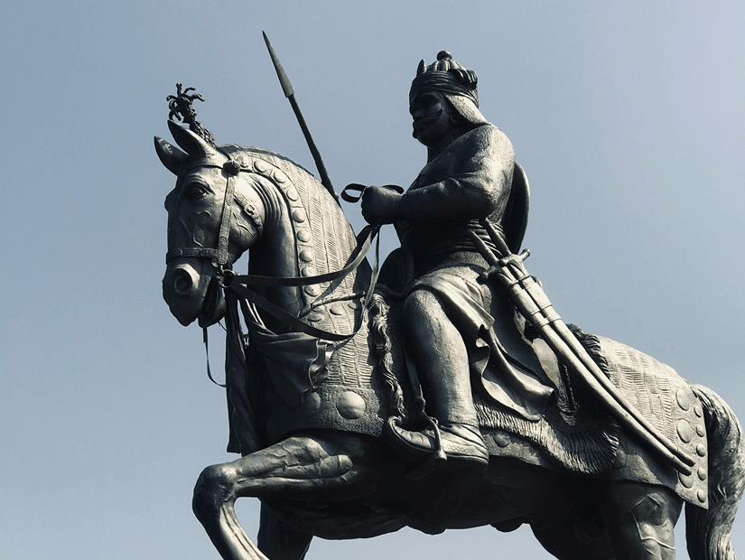 Equestrian statue of Maharana Pratap on horseback, commemorating the Rajput ruler against a pale sky with the statue's pedestal below