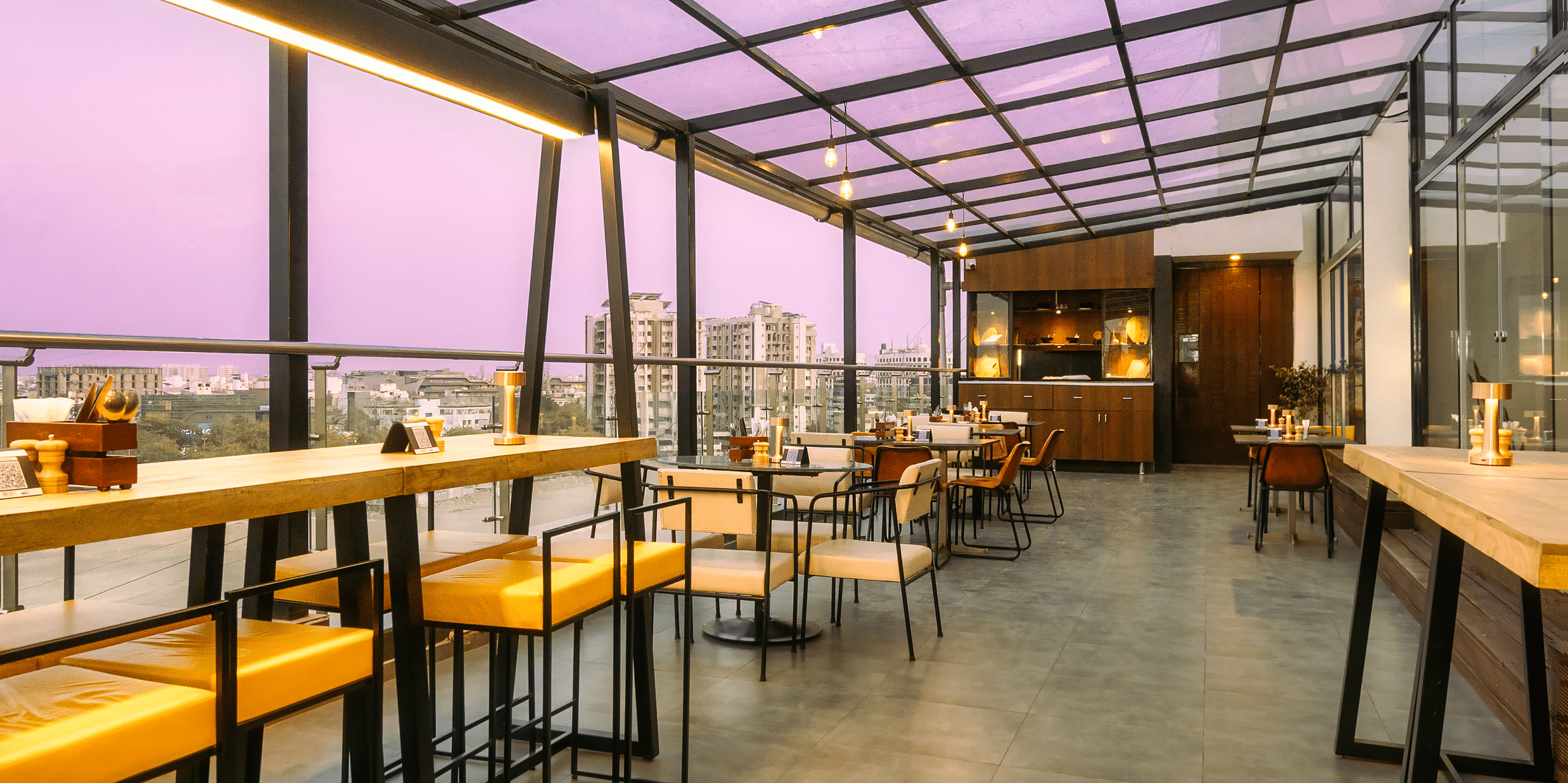  A long shot of the rooftop cafe with comfy seating and beautiful view at at Marasa Sarovar Portico, Rajkot