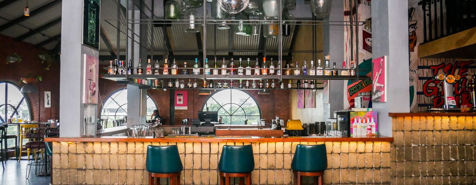 A vibrant hotel bar with stylish high chairs and a well stocked counter, ready for drinks at Shilton Dee Cee.