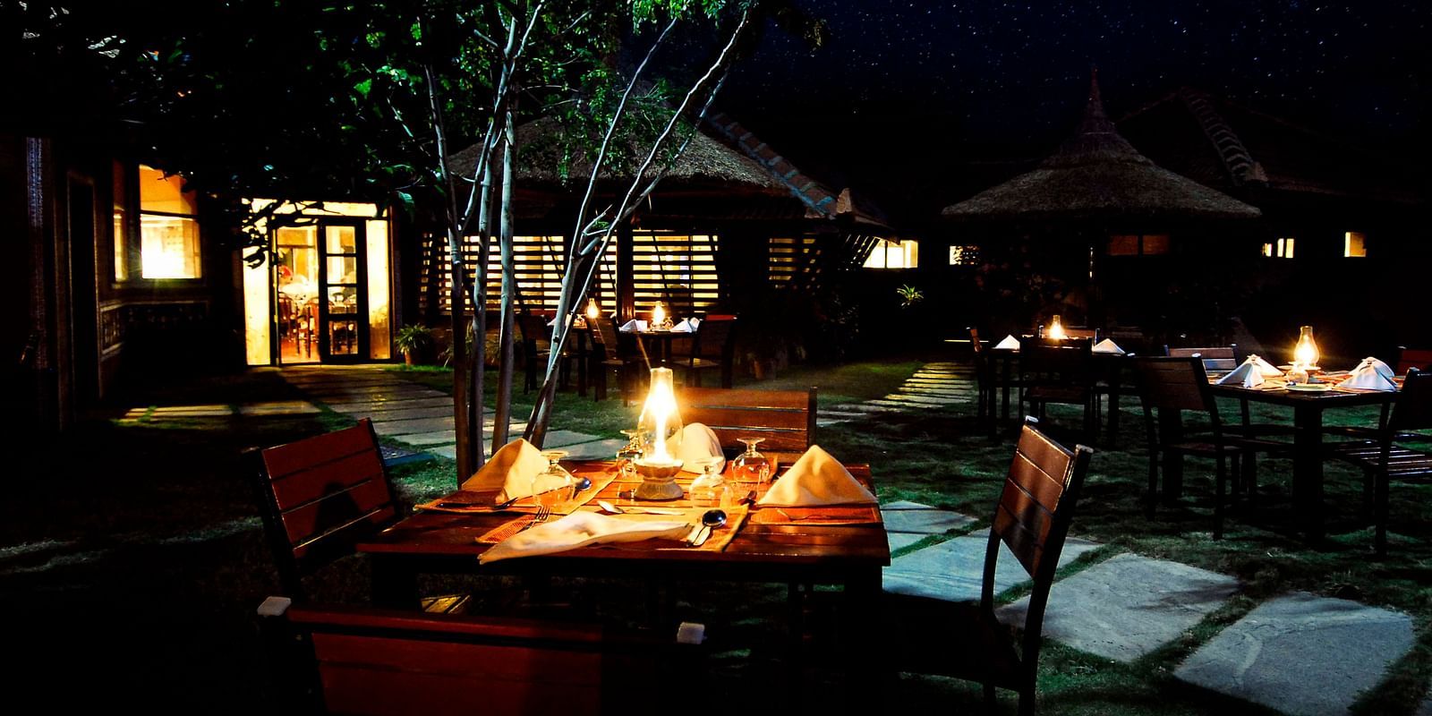 image of a candle light dinner table in the garden of the hoysala village resort, hassan