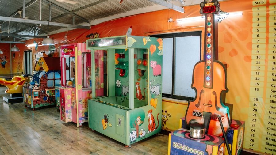 A wide view of the arcade games room showing 3 large machines, at Daksh Resort & Amusement Park, Sasan Gir.