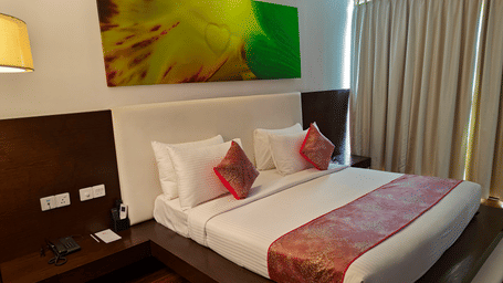 Suite with a king size bed with a wall hanging over its headboard and a telephone on the nightstand beside it at Springs Hotel & Spa