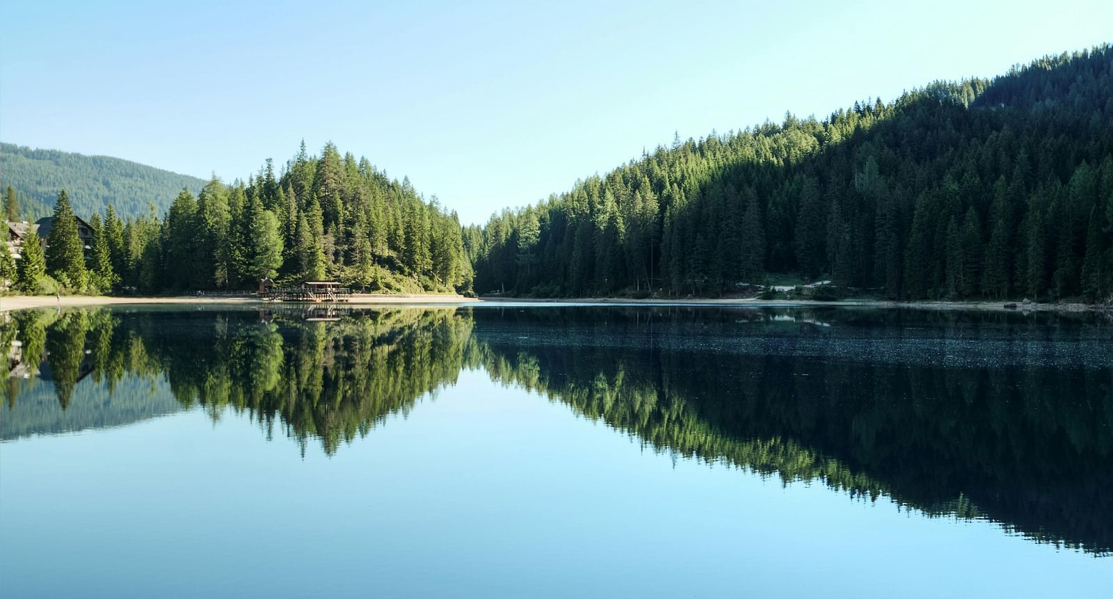 image of a serene lake with lush green forest in the background