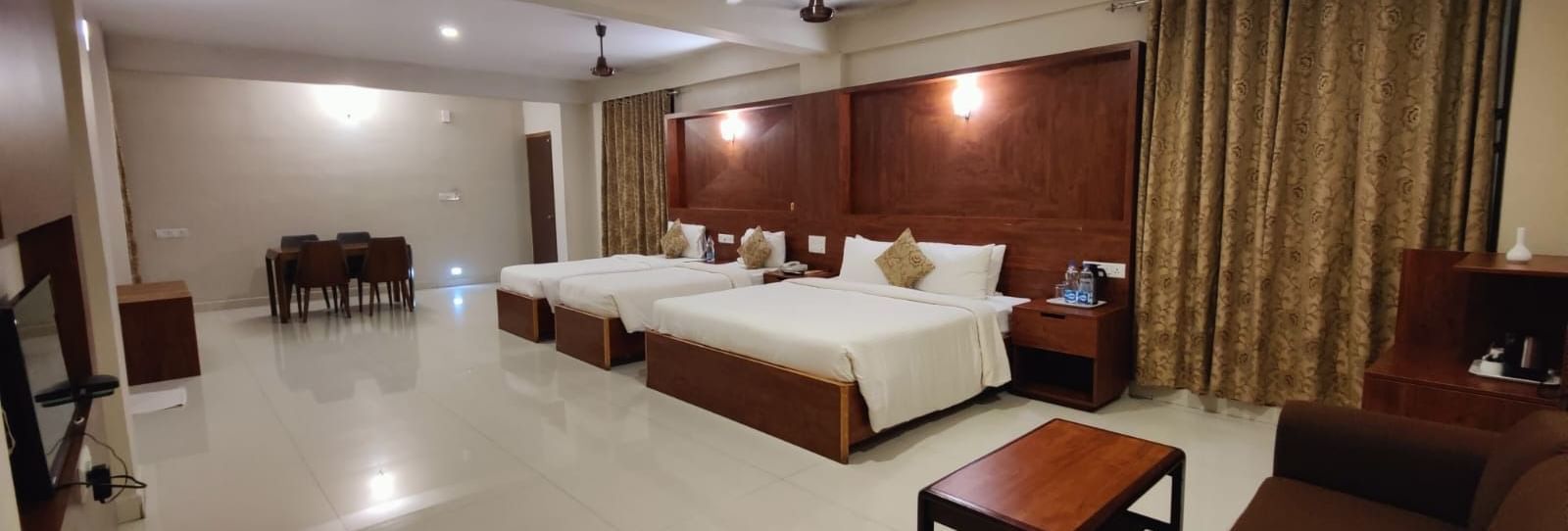 Spacious Deluxe Family Room at Woodstock Resorts, Coorg with twin beds, wooden furniture, and bright, airy interiors.