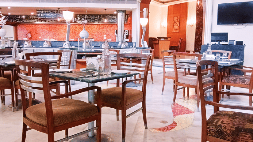 Brightly lit restaurant interior with neatly arranged tables and chairs, showcasing a formal dining setup.