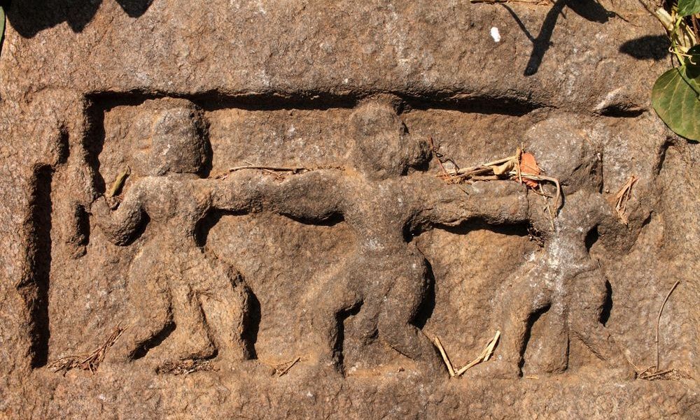 Ancient stone carving of figures in relief.