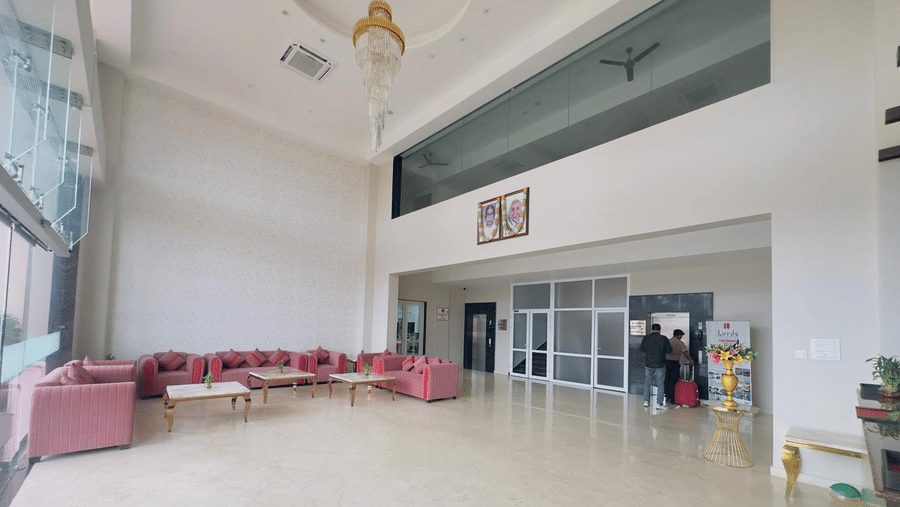A spacious lobby with pink sofas, large windows, and a polished light-coloured floor is pictured - Kankidham Lords Inn