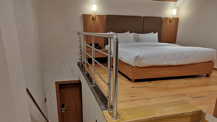 Loft-style bedroom with a double bed, bunk bed, wooden steps, and railing
