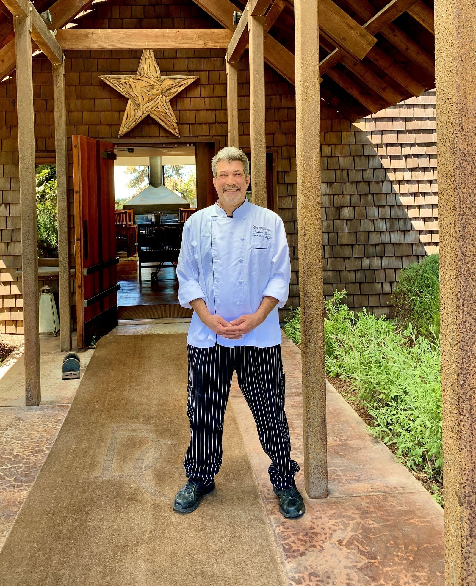 A staff member standing in the rustic wooden entranceway - Brewery Gulch Inn & Spa