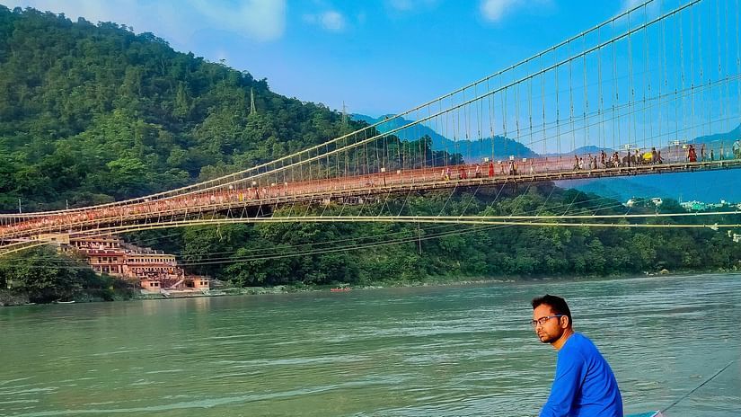 Man sitting near Lakshman Jhula, one of the best places to visit in Rishikesh