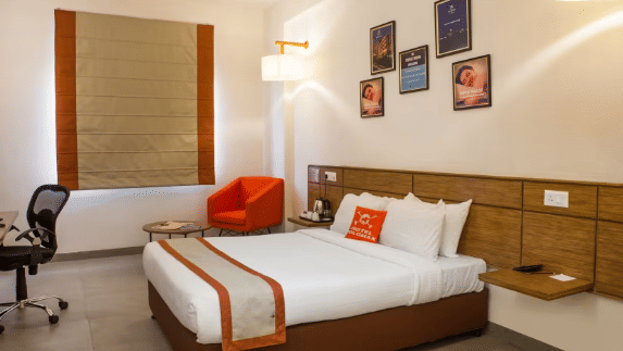 A side view of comfy room with study table and a comfy sofa. | Polo Max Hotels