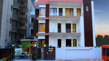 Multiple storey building exterior of Lime Tree Hotels & Service Apartment Private Limited illuminated at dusk.