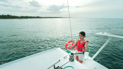 a girl sailing a yacht in a sea