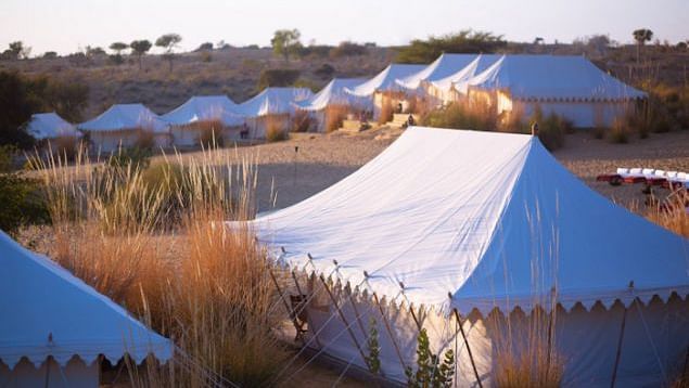 An image of the tent area at MANVAR Resort & Desert Camp in the desert with sparse greenery