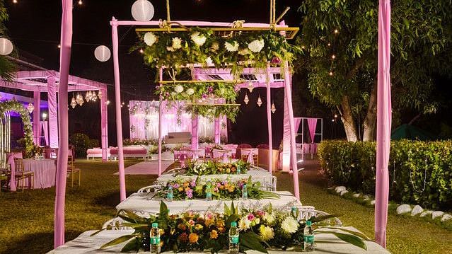 alt-text Elegant dining table with floral centerpieces and warm lighting.