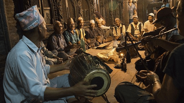 Group of local Newari men playing traditional drums and instruments during an evening musical gathering in Bhaktapur, Nepal.