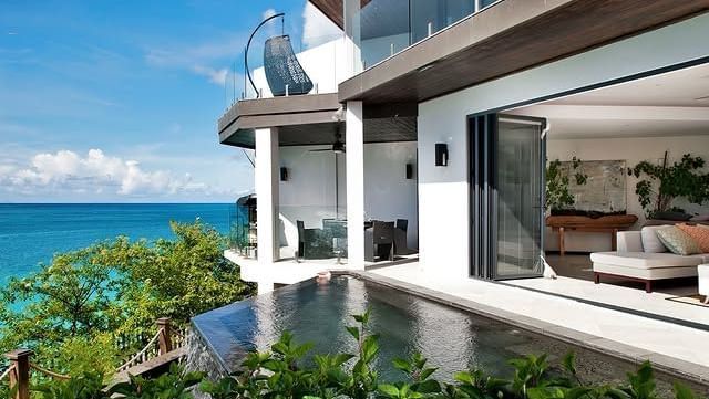 A luxurious modern oceanfront resort with an infinity pool and private terraces overlooking the turquoise Caribbean Sea.
