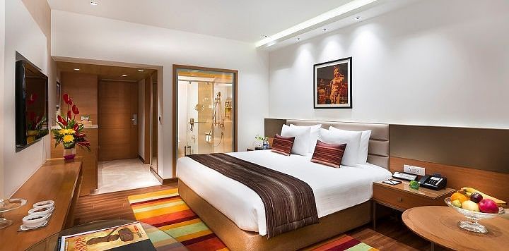 Business Class Room with a king size bed and a TV at Grand Chennai By GRT Hotels.