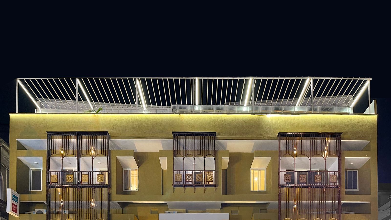 A close image of the front view of Bedzzz Varanasi, captured in the evening, well lit and featuring the logo of the property and the roof top area.