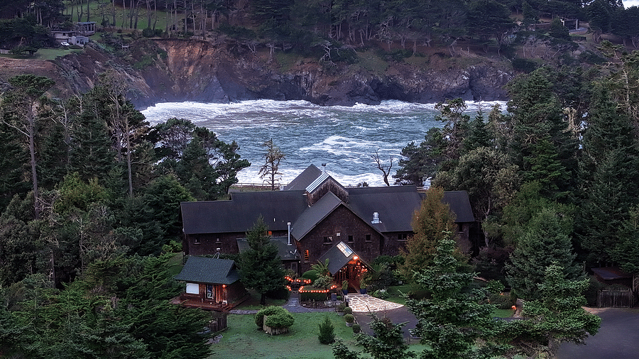 Waves of Mendocino coast crashing against the shore situated behind a hotel - Brewery Gulch Inn & Spa