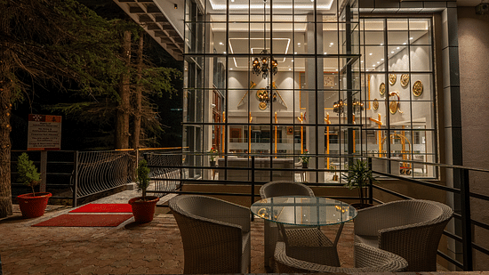 an image of outdoor seating space with chairs and a round table at Mastiff Select Mandavya Dharamkot, McLeodganj