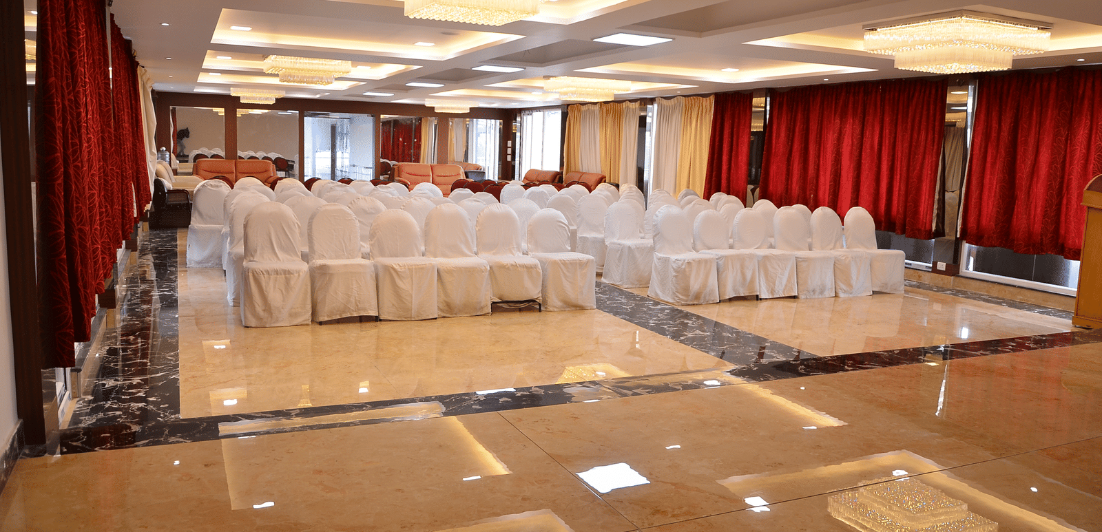 A banquet hall with bright lights and organised seating, perfect for conferences and celebrations - Benzz Park, Kodaikanal