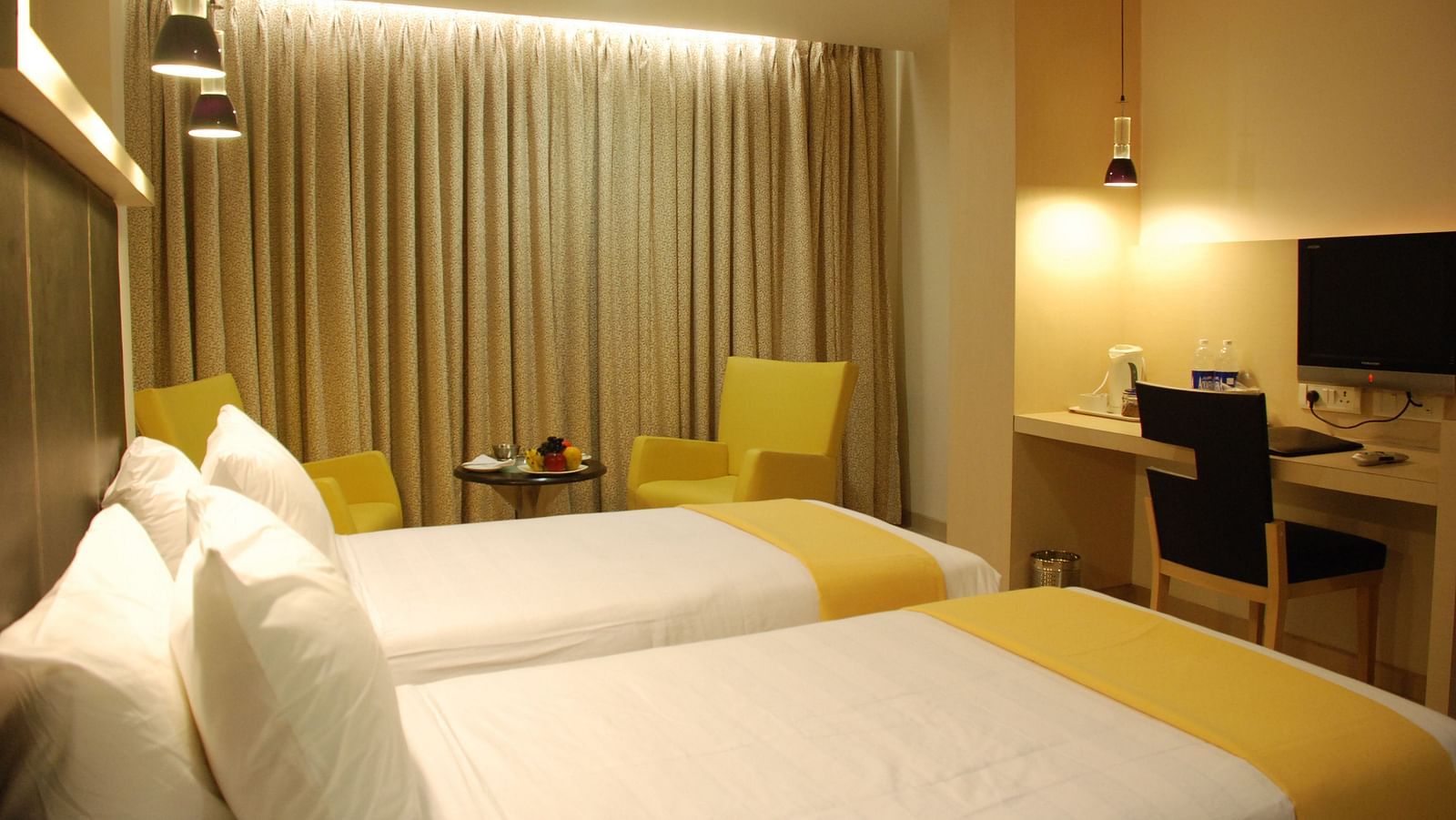 Image of a room with seating area, twin beds and a television in front at The Oriental Residency